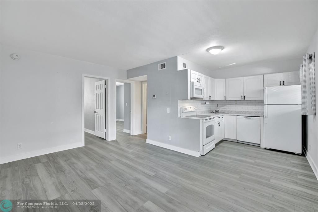 2741 Northeast 8th Avenue, Unit 15 Wilton Manors, FL 33334 - Photo 4 of 46 a kitchen with stainless steel appliances cabinets a wooden floor and a sink