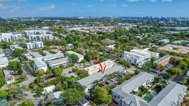 an aerial view of residential houses with outdoor space and trees