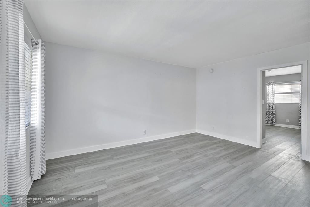 2741 Northeast 8th Avenue, Unit 15 Wilton Manors, FL 33334 - Photo 5 of 46 an empty room with wooden floor & windows