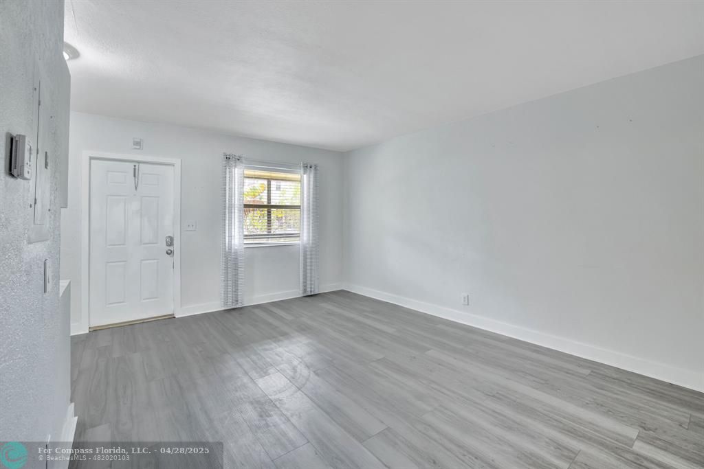 2741 Northeast 8th Avenue, Unit 15 Wilton Manors, FL 33334 - Photo 7 of 46 an empty room with wooden floor and window