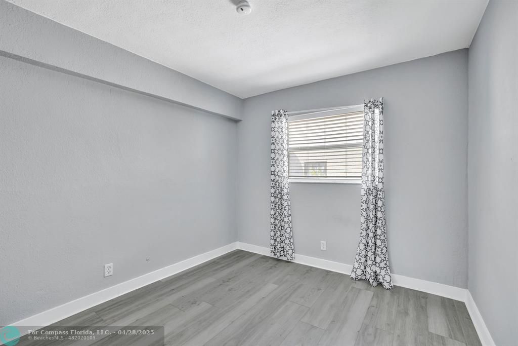 2741 Northeast 8th Avenue, Unit 15 Wilton Manors, FL 33334 - Photo 10 of 46 an empty room with wooden floor and windows