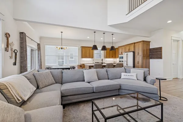 a kitchen with stainless steel appliances granite countertop a stove a sink a dining table and chairs with wooden floor