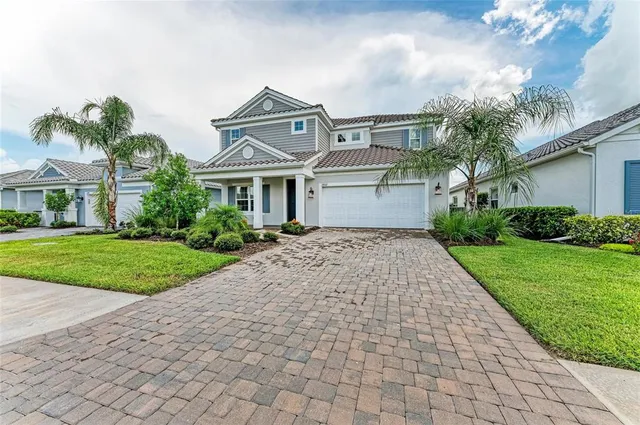 a front view of a house with a yard and potted plants