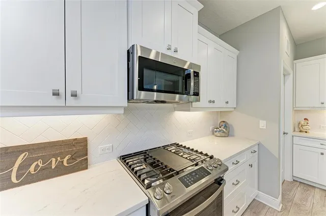 a kitchen with a stove a sink and a wooden cabinets