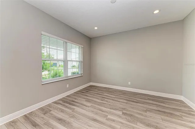 a kitchen with stainless steel appliances granite countertop a refrigerator a sink dishwasher a stove and white cabinets with wooden floor