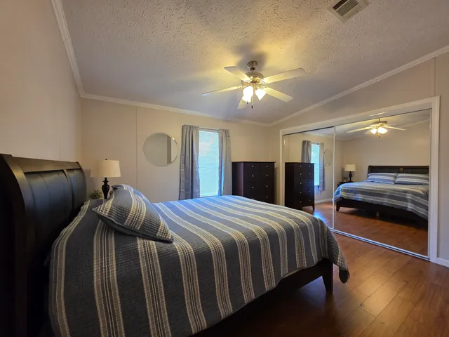 a bedroom with bed and wooden floor