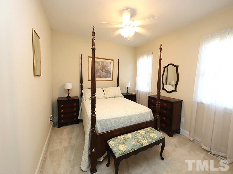 4100 Heathgate Lane Raleigh, NC 27613 - Photo 12 of 25 a bedroom with a bed a chandelier and dresser