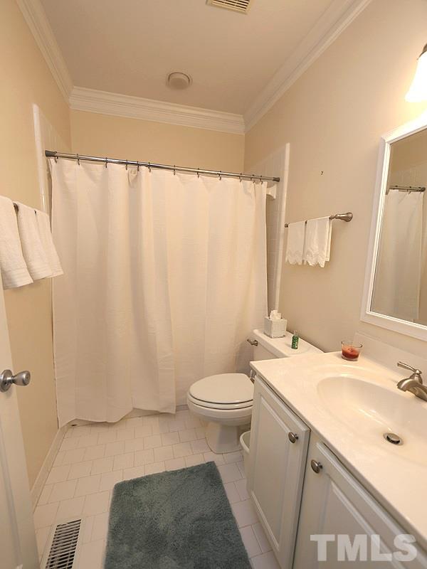4100 Heathgate Lane Raleigh, NC 27613 - Photo 13 of 25 a bathroom with a sink a toilet and shower curtain