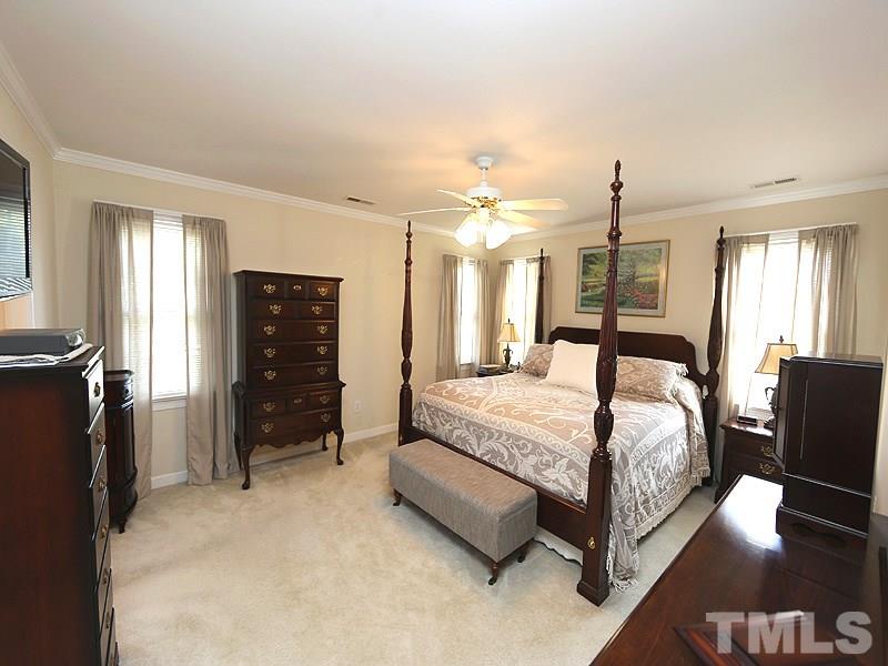 4100 Heathgate Lane Raleigh, NC 27613 - Photo 14 of 25 a large bedroom with a bed and wooden floor