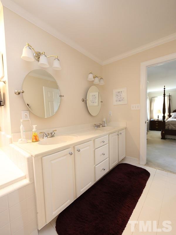 4100 Heathgate Lane Raleigh, NC 27613 - Photo 15 of 25 a spacious bathroom with a double vanity sink and a mirror