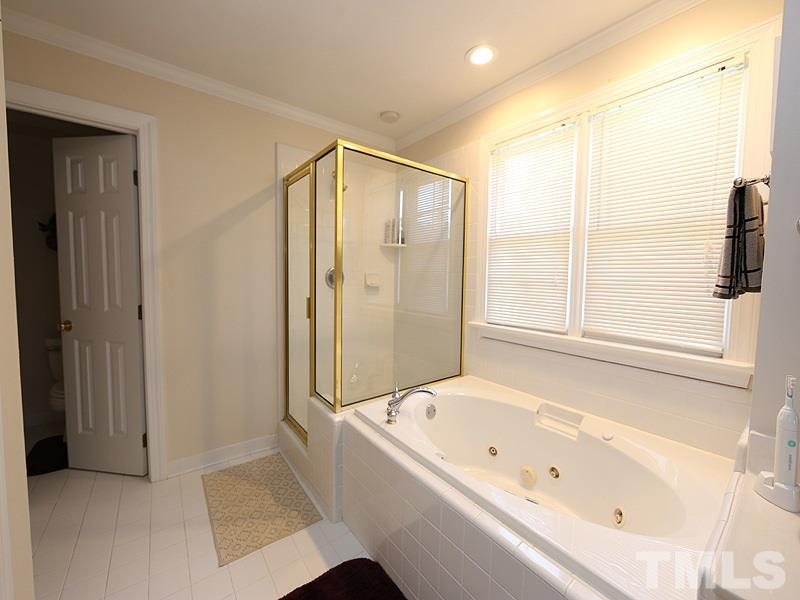 4100 Heathgate Lane Raleigh, NC 27613 - Photo 16 of 25 a bathroom with a bathtub and a shower