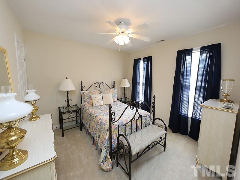 4100 Heathgate Lane Raleigh, NC 27613 - Photo 17 of 25 a spacious bedroom with a bed and a chandelier