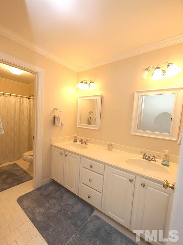 4100 Heathgate Lane Raleigh, NC 27613 - Photo 19 of 25 a spacious bathroom with a double vanity sink and a mirror