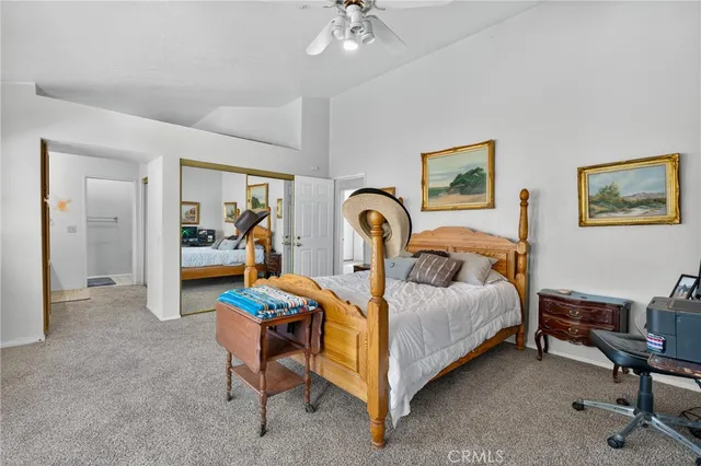 a bedroom with a bed a lamp on desk and a window