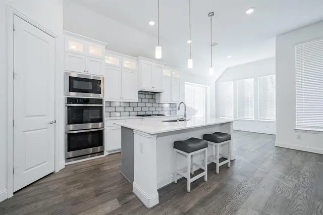 a kitchen with kitchen island a stove a sink and a refrigerator