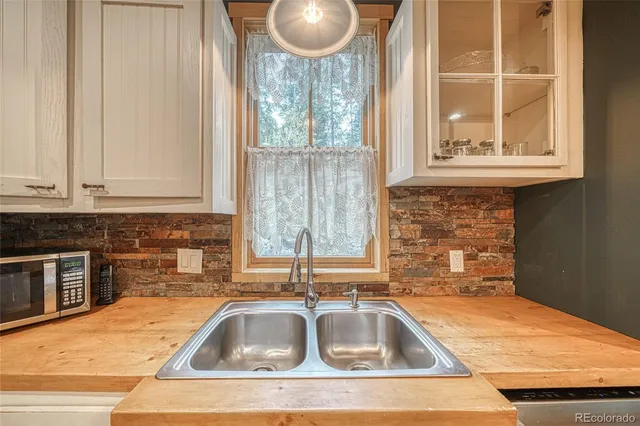 a kitchen with granite countertop a sink and a wooden floor