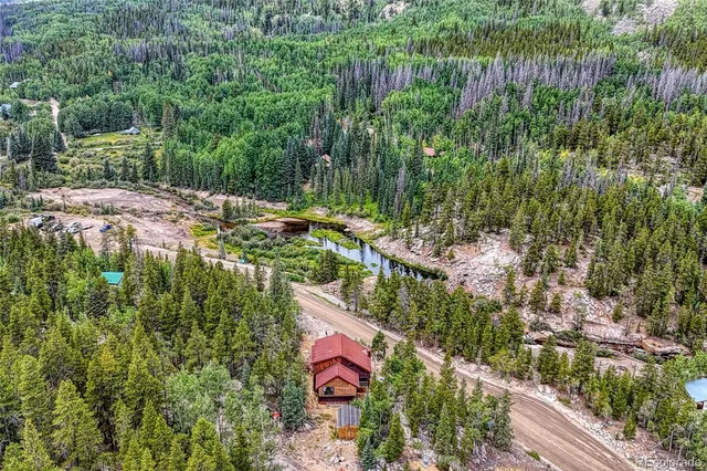 a aerial view of residential house with outdoor space and trees