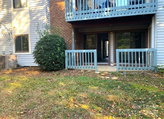 a view of a house with wooden deck and furniture