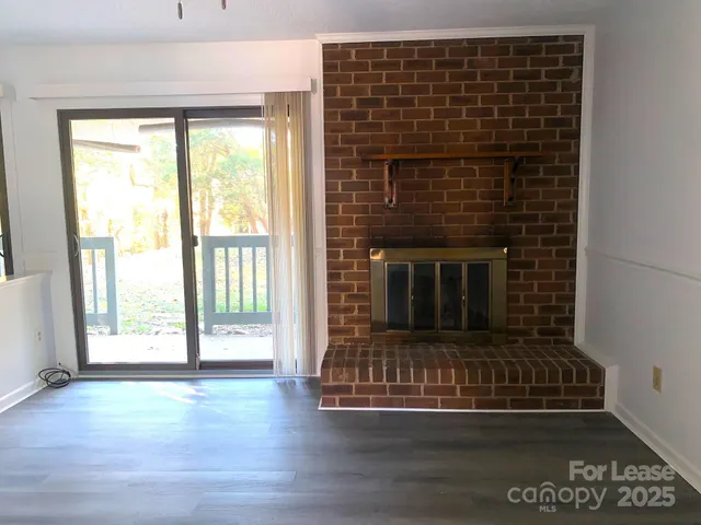 a living room with fireplace and wooden floor