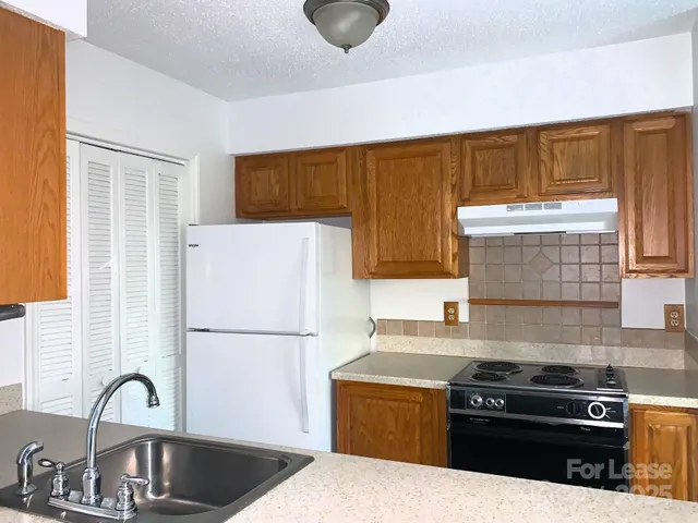 a kitchen with a stove a refrigerator and a sink