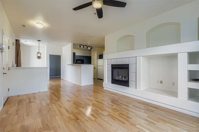 an empty room with kitchen and fireplace