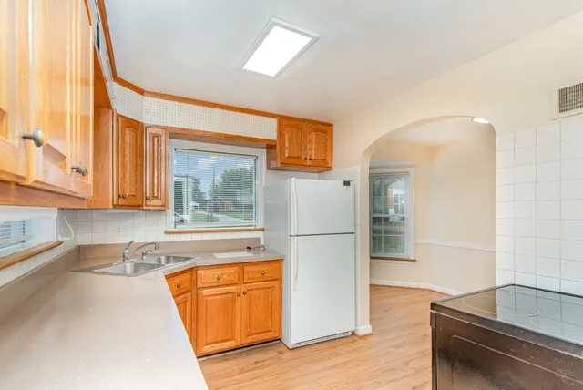 a kitchen with a refrigerator a sink and cabinets