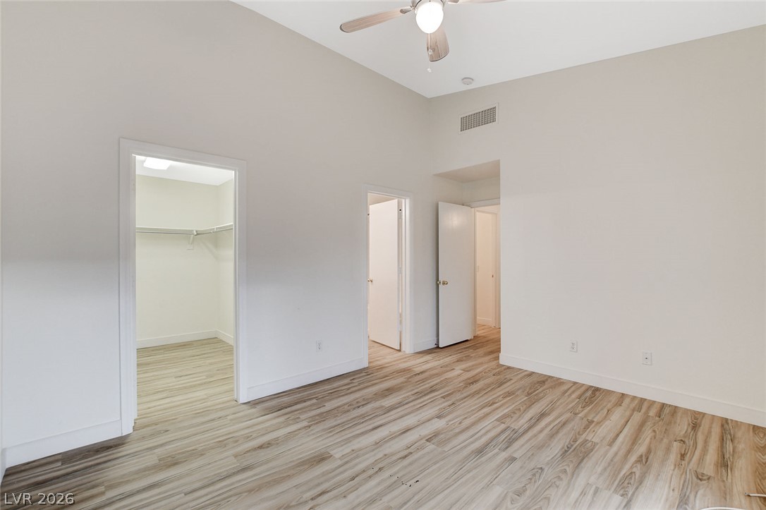 2052 Quarry Ridge Street, Unit 201 Las Vegas, NV 89117 - Photo 17 of 25 A well-lit bedroom features high ceilings and durable vinyl plank flooring, with easy access to a spacious walk-in closet.