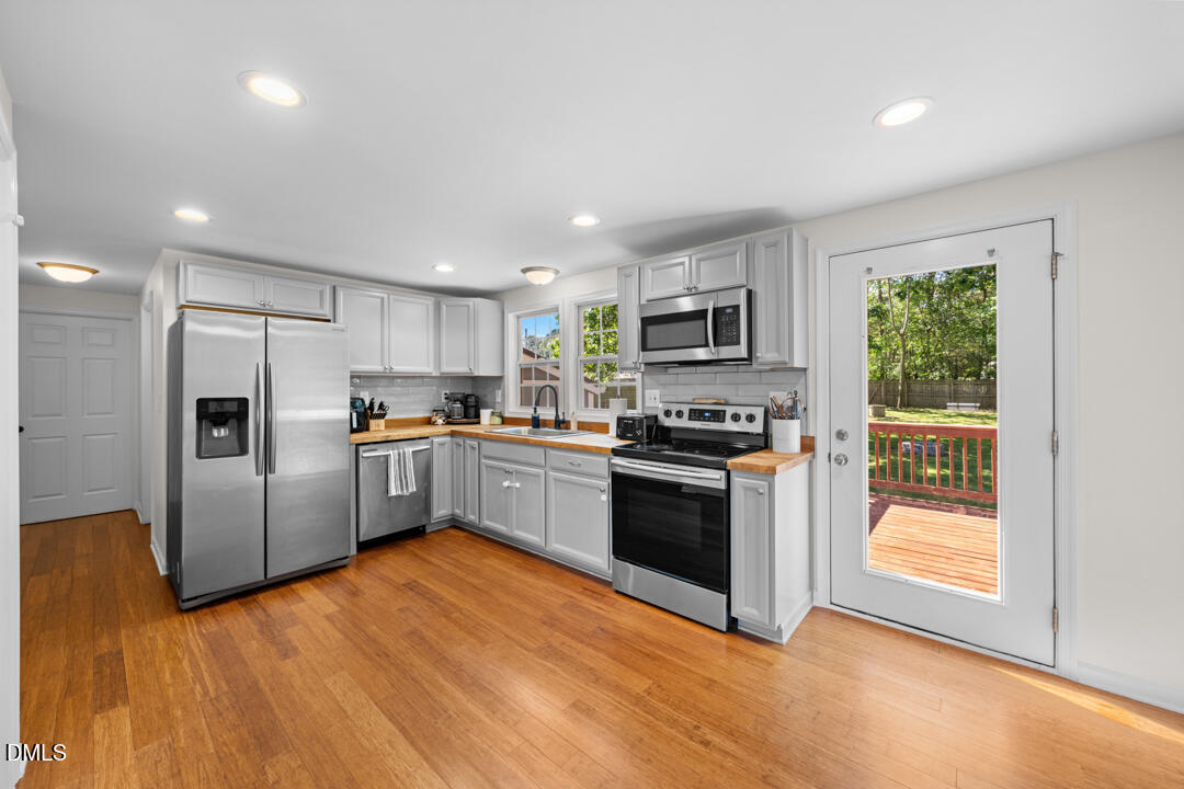 454 Cedar Creek Road Timberlake, NC 27583 - Photo 15 of 39 a kitchen with granite countertop a refrigerator and a stove top oven