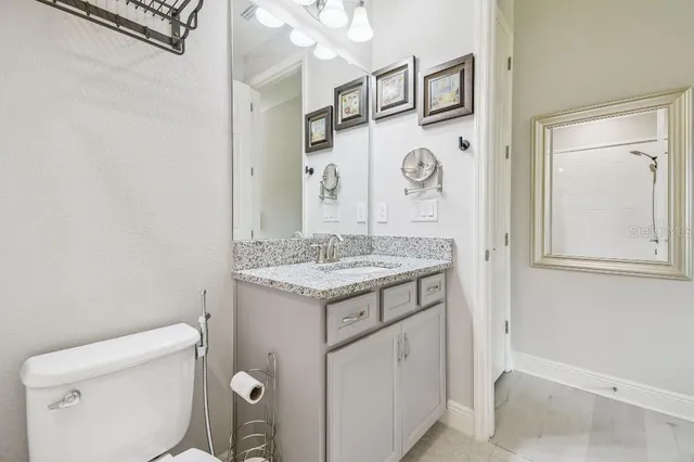 a bathroom with a granite countertop shower and a toilet