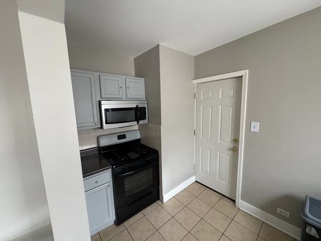 a kitchen with a refrigerator and a stove top oven
