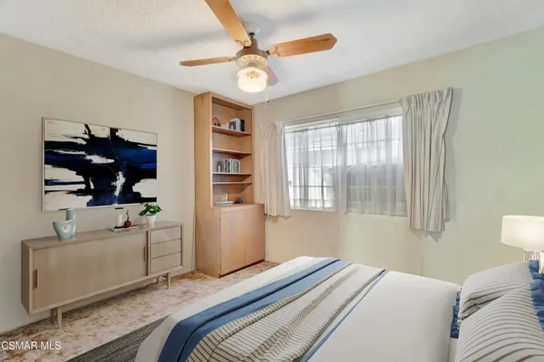 a bedroom with a bed and a large window