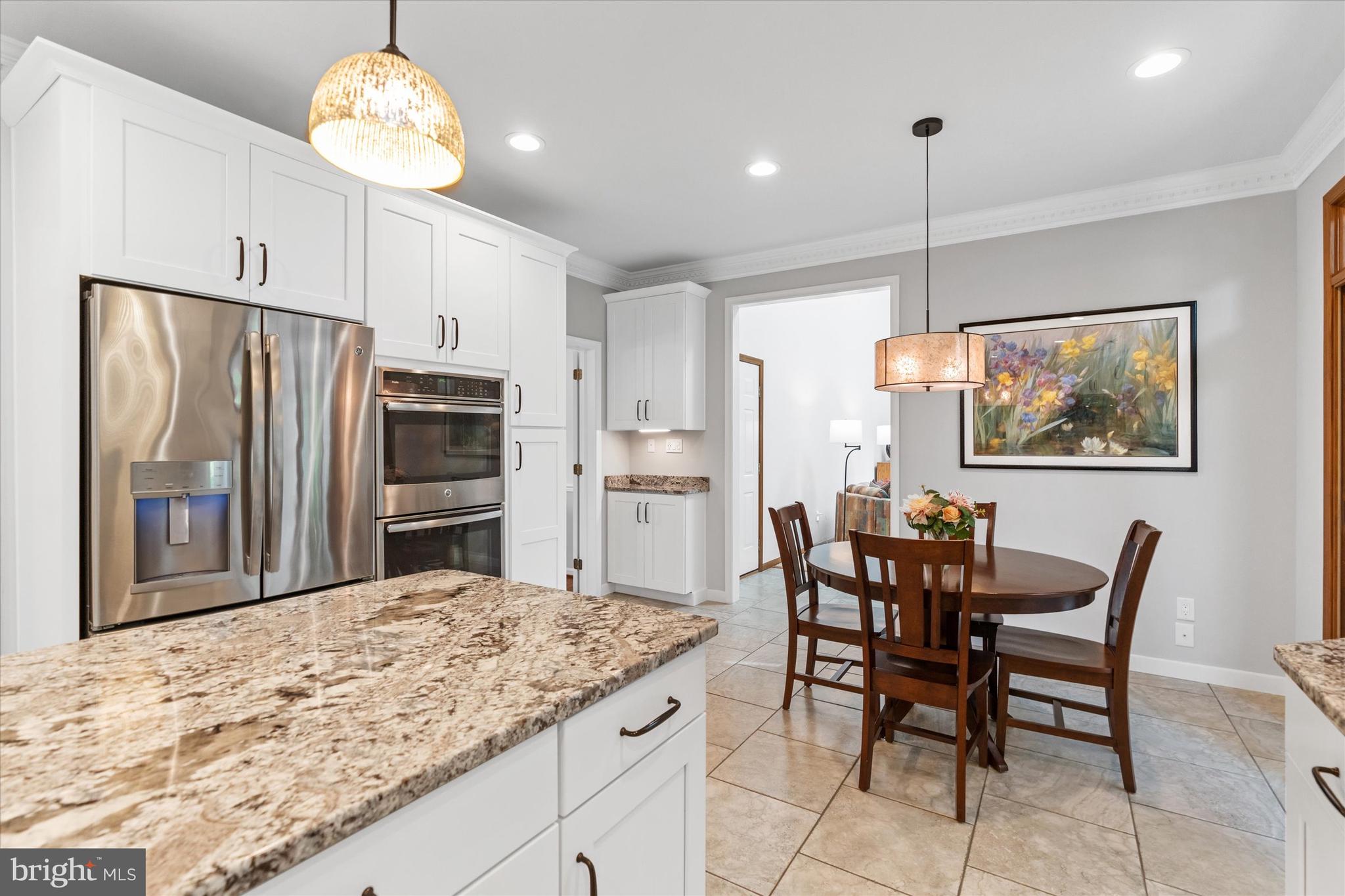 216 South Pond Road Hockessin, DE 19707 - Photo 15 of 61 a kitchen with stainless steel appliances granite countertop a refrigerator a stove a kitchen island a table and chairs with wooden floor