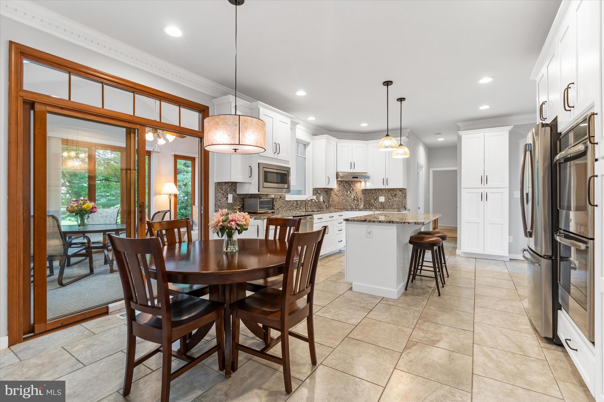216 South Pond Road Hockessin, DE 19707 - Photo 16 of 61 a dining room with stainless steel appliances kitchen island granite countertop a dining table chairs and granite counter tops