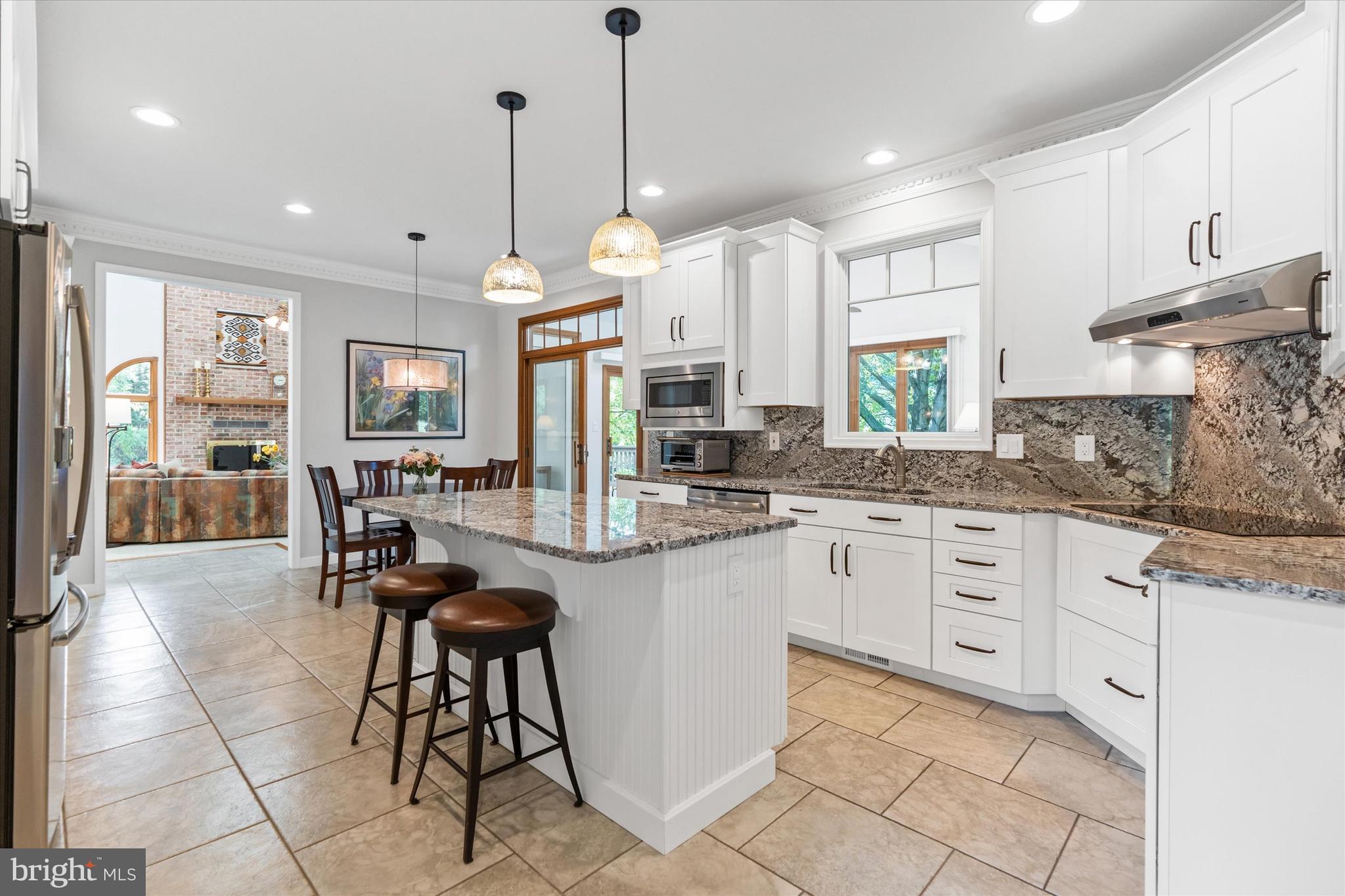 216 South Pond Road Hockessin, DE 19707 - Photo 10 of 61 a kitchen with stainless steel appliances kitchen island granite countertop a stove a sink a dining table and chairs