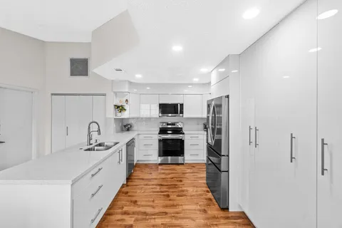 a large kitchen with stainless steel appliances kitchen island a refrigerator sink and stove