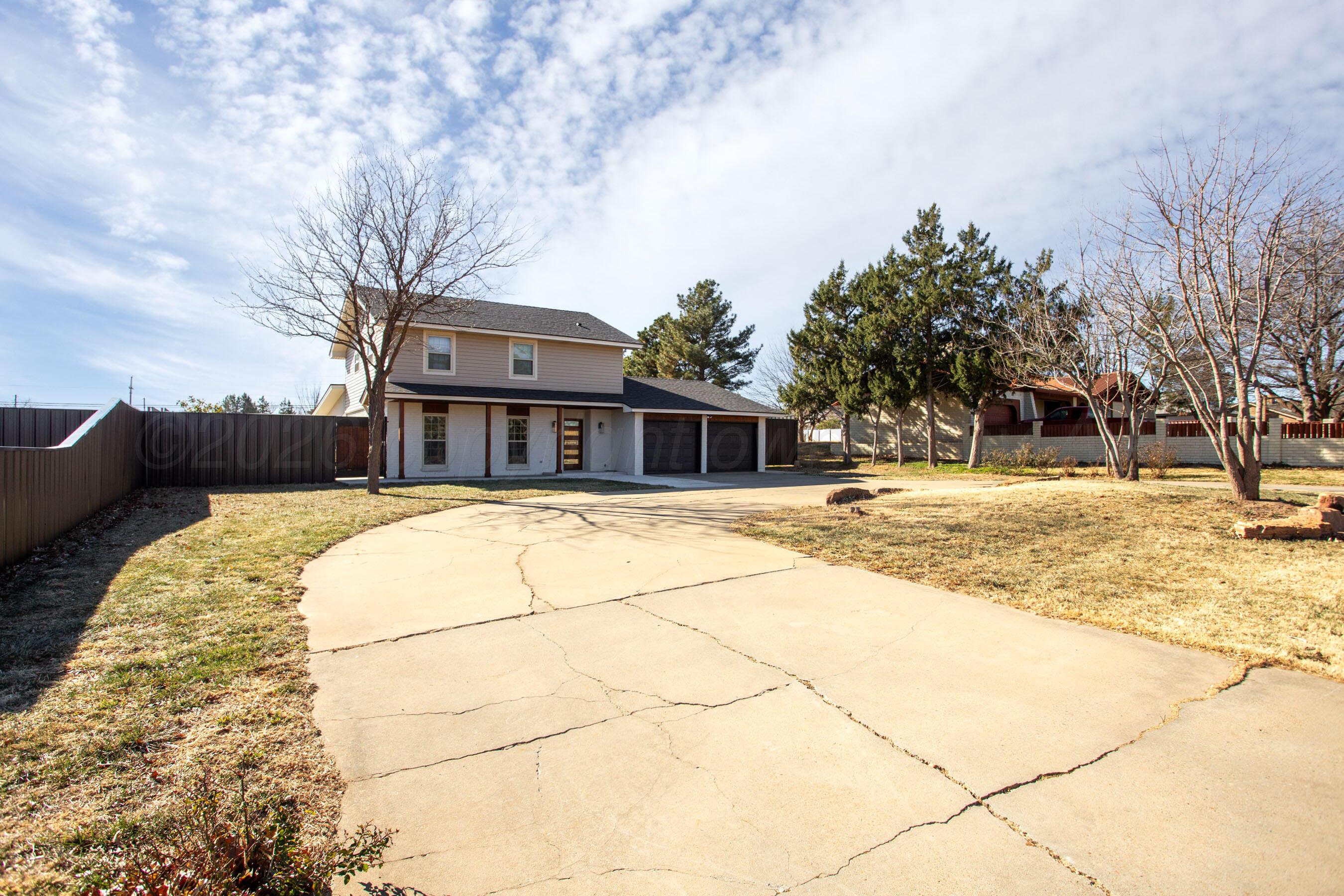 a front view of a house with large trees
