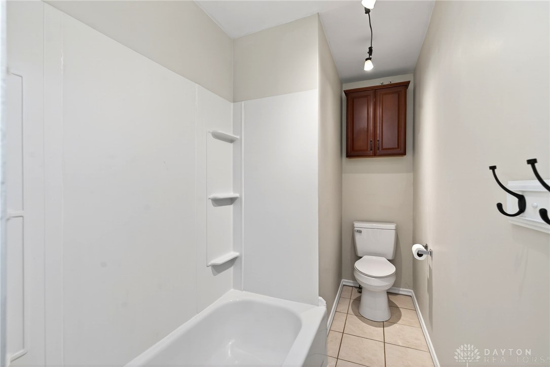 585 North Spring Street Wilmington, OH 45177 - Photo 15 of 21 This bathroom features practical shelving and an overhead cabinet, optimizing storage in a compact layout.