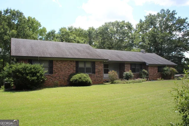 a view of house with yard and outdoor seating
