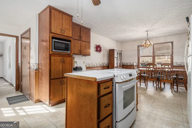 a kitchen with kitchen island granite countertop a stove and a refrigerator
