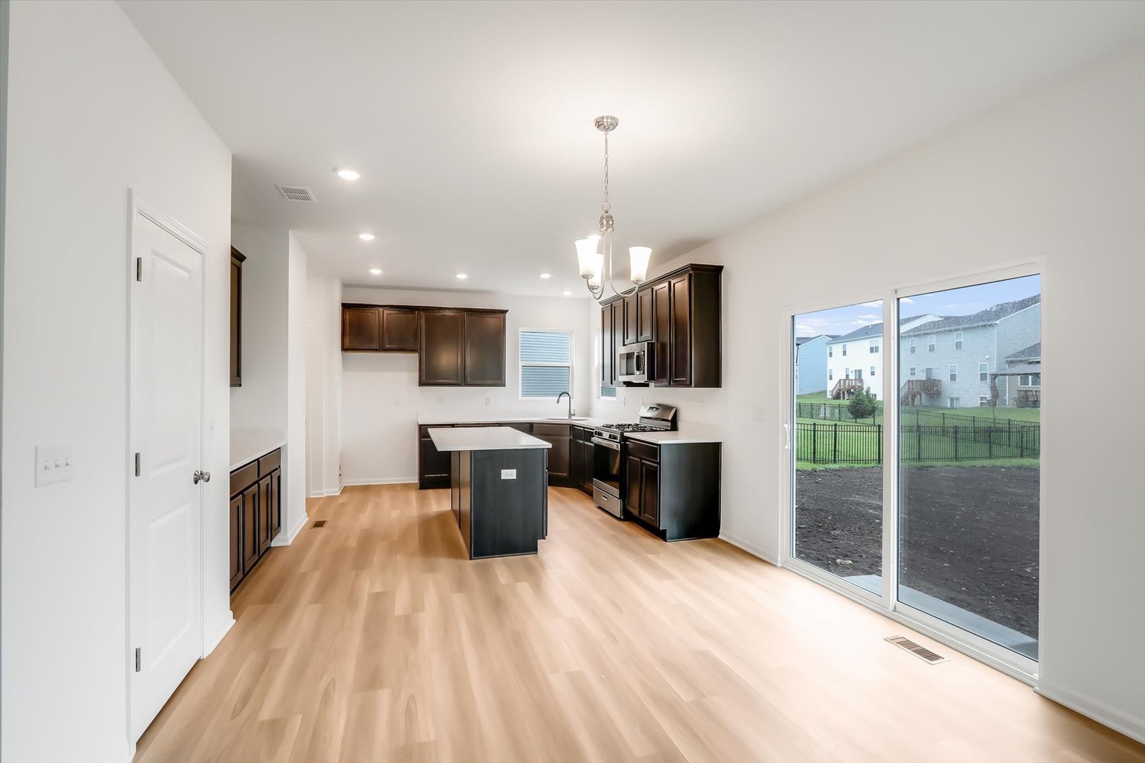 468 Endicott Road South Elgin, IL 60177 - Photo 6 of 32 a open kitchen with stainless steel appliances granite countertop a stove top oven a sink dishwasher a dining table and chairs with wooden floor