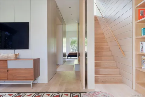 a view of a hallway with wooden floor and cabinet