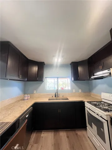 a kitchen with stainless steel appliances kitchen island granite countertop a sink and a stove