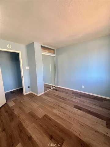 an empty room with wooden floor and closet