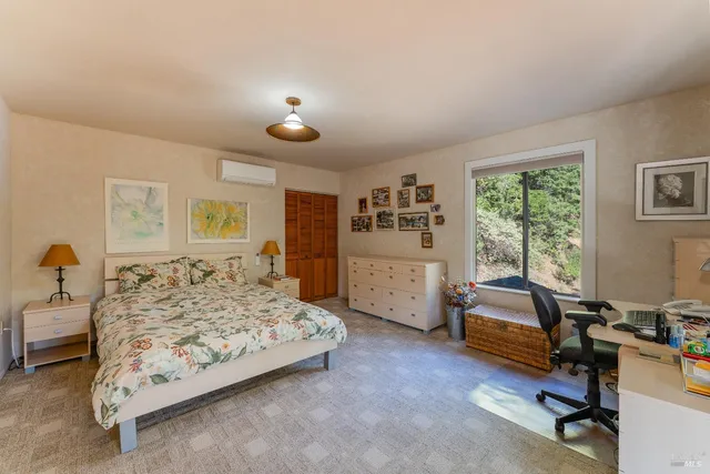 a bedroom with furniture and a large window