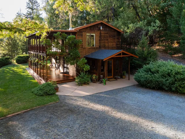 a front view of a house with yard and trees