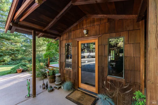 a patio with wooden floor a yard tables and chairs