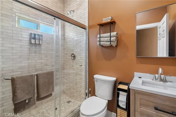 a bathroom with a toilet a sink and mirror