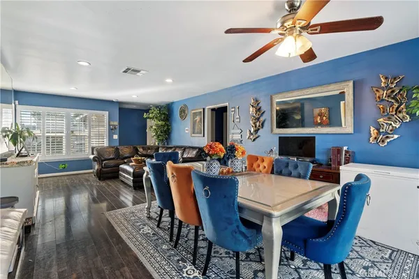 a view of a dining room with furniture a chandelier and wooden floor