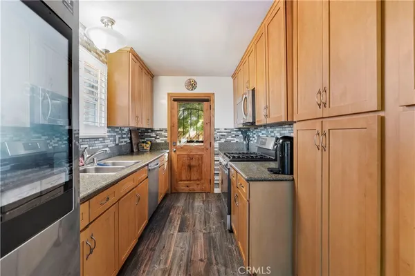 a kitchen with stainless steel appliances granite countertop a stove a sink and a refrigerator