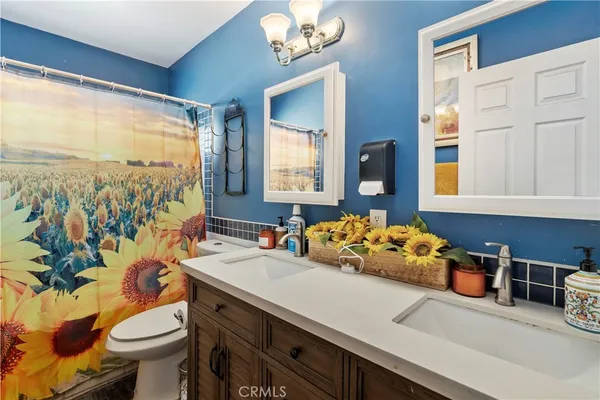 a bathroom with a sink vanity mirror and toilet